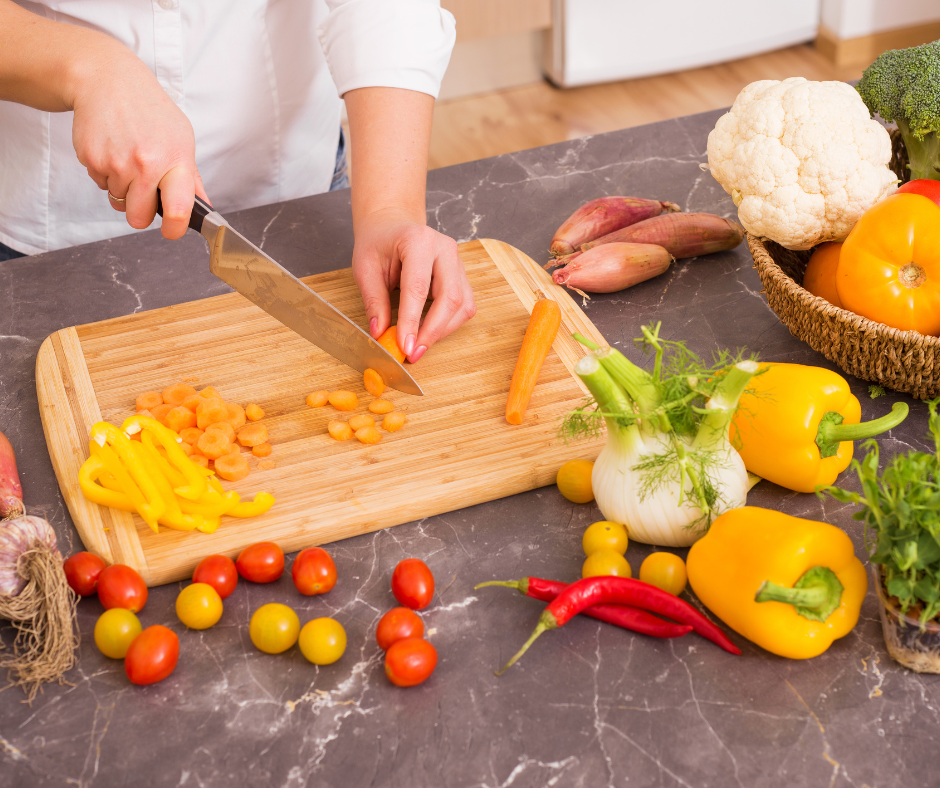 A person chopping vegetables on a cutting board.