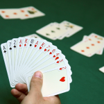 A stock image of a person holding a fanned out hand of cards.